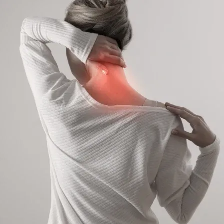 Person holding the back of the neck while the upper neck and shoulder area is highlighted in red.